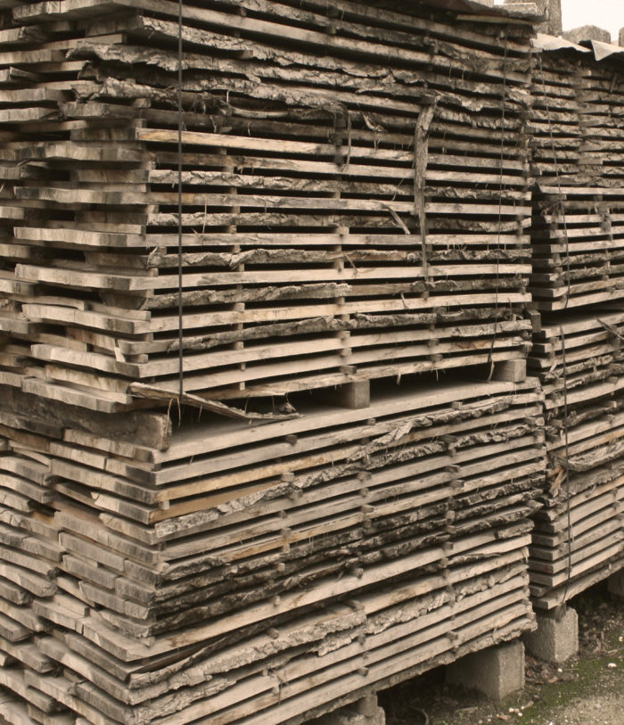 Cataste di legno in stagionatura all'aria aperta nel piazzale del laboratorio